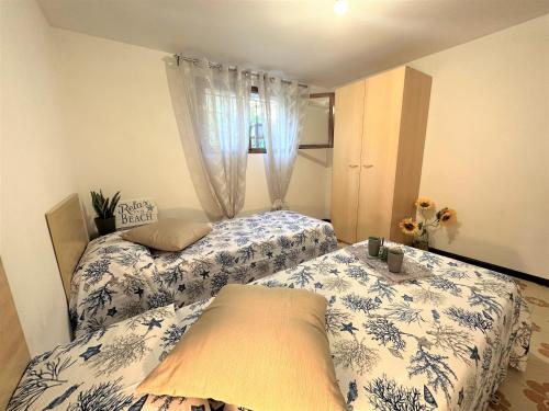 a bedroom with two beds with blue and white sheets at Villa Luisa in Lignano Sabbiadoro