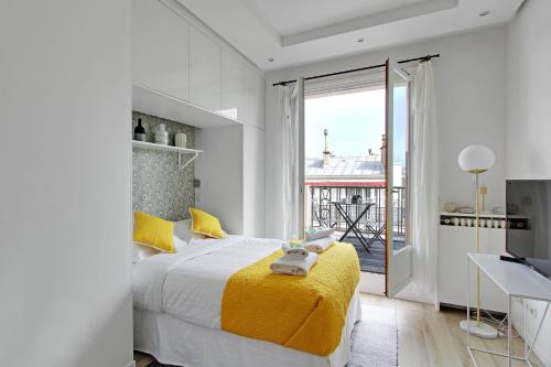 パリにあるPick A Flat's Apartment in Madeleine - Boulevard de la Madeleineのベッドルーム1室(黄色い毛布付きのベッド1台付)