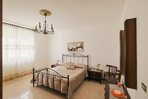 1 dormitorio con cama y lámpara de araña en Le Rose di Lena en Copertino