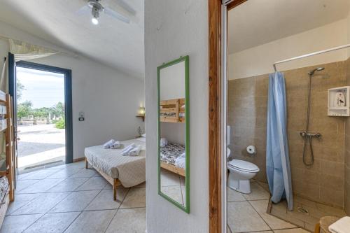 uma casa de banho com uma cama, um chuveiro e um WC. em Eliados - Bungalow 1 em Diso