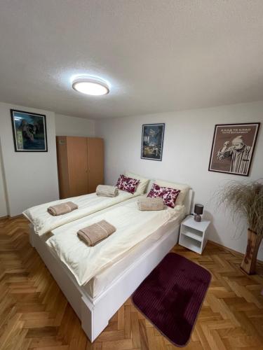 a bedroom with a large white bed in a room at Apartmani Stanković Sokobanja in Soko Banja