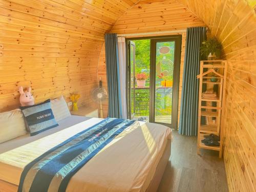 a bedroom with a bed in a wooden room at Plum Homestay in Dồng Văn
