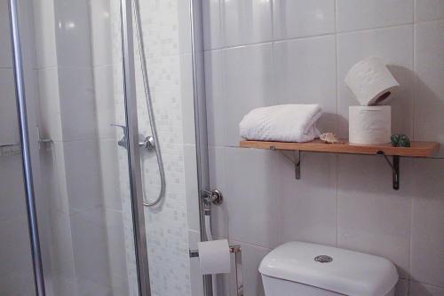 a bathroom with a shower and a toilet and towels at Vale a Pena - Alojamento Local in Trancoso