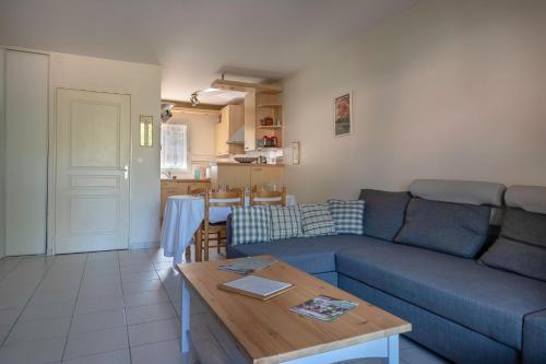 un salon avec un canapé bleu et une table dans l'établissement Maison à 500m de la plage pour 4, à Saint-Brévin-les-Pins