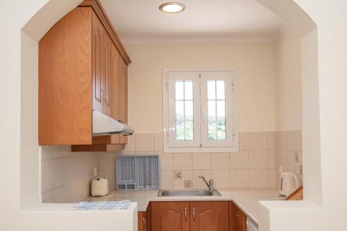 a kitchen with a sink and a window at Kapetanios Apartments in Agios Stefanos