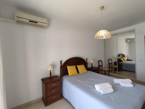 アルマカオ・デ・ペラにある2 Avenida Frente Mar - Casas & Papéisのベッドルーム1室(ベッド1台、タオル2枚付)