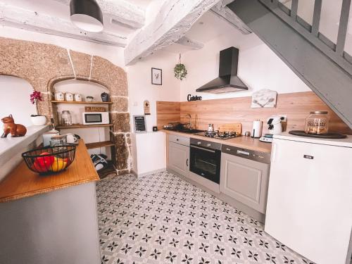a kitchen with a sink and a stove top oven at Mon Petit Coin de Paradis in Golinhac