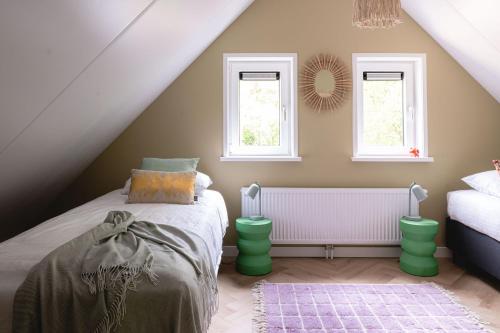寧斯佩特的住宿－Luxe Vakantiehuis Huismus Veluwe，一间卧室设有一张床和两个窗户。