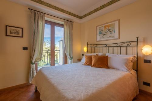 a bedroom with a large bed and a balcony at Carpediem Roma Golf Club in Marco Simone