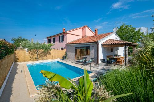 a villa with a swimming pool in front of a house at Holiday house Mara with a private pool in Vodnjan