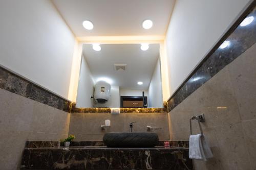 a bathroom with a large mirror and a sink at marron studios 4 new in Cairo