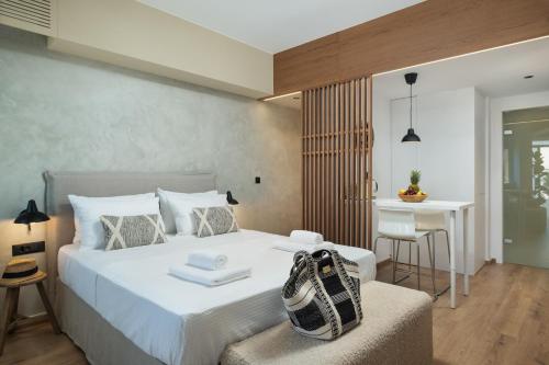 1 dormitorio con 1 cama con una bolsa en una silla en Nomas lifestyle living en La Canea