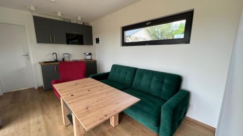 ein Wohnzimmer mit einem grünen Sofa und einem Tisch in der Unterkunft W Kręgu Natury 