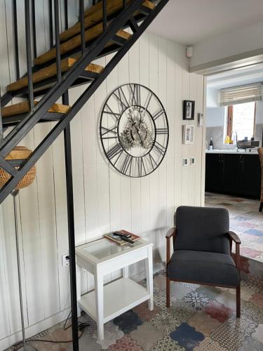 a clock on a wall with a chair and a table at Angliiska Vila in Arbanasi