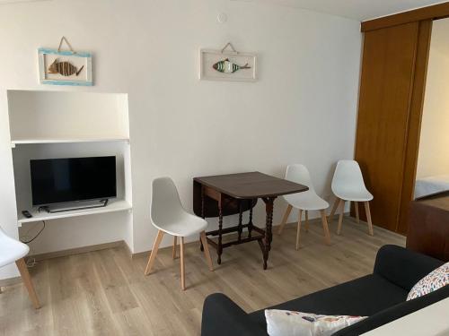 een woonkamer met een tafel, stoelen en een televisie bij La Casetta in Lerici
