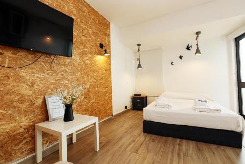 um quarto com uma cama e uma televisão na parede em A57 - Lighthouse Apartment in Via Dona Ana Lagos em Lagos