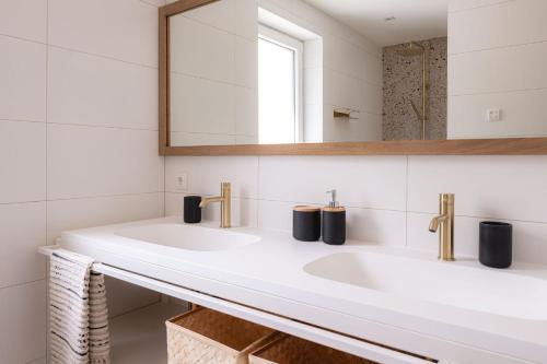 ein Badezimmer mit 2 Waschbecken und einem Spiegel in der Unterkunft Luxe Vakantiehuis Huismus Veluwe in Nunspeet