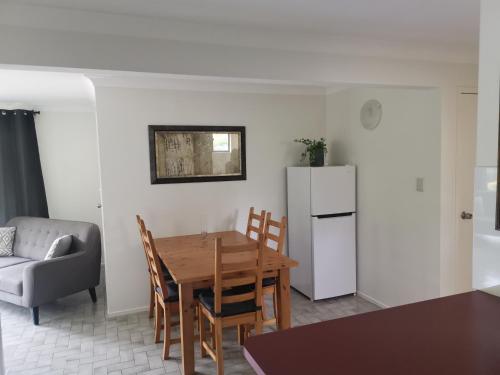 a kitchen and dining room with a table and a refrigerator at Rural Escape in Boambee