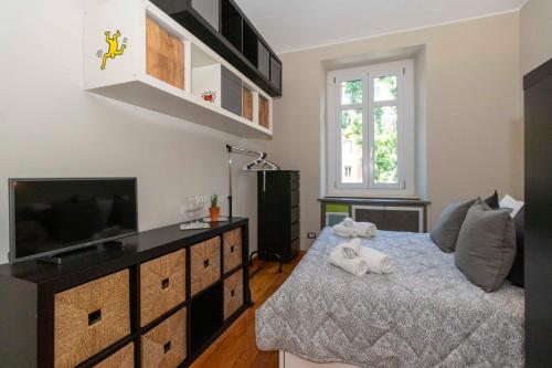 a bedroom with a bed and a flat screen tv at Exploring Turin: Crocetta Mini Flat in Turin