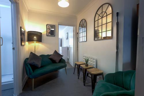 sala de estar con sofá verde y sillas en Trendy 2Bed flat Bethnal Green, en Londres