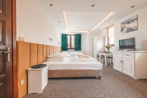 Habitación de hotel con 4 camas y TV en Apartamenty u Semlów, en Szaflary