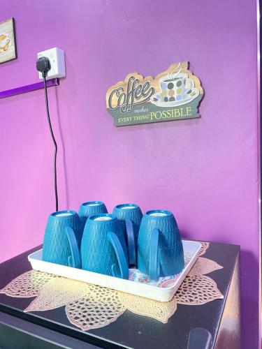 a table with blue vases on top of it at AISY HOMESTAY - Rumah 2,3 in Kampong Tanjong Karang
