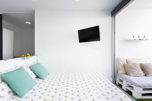 a bedroom with a bed and a flat screen tv at Front beach studio in Callao Salvaje