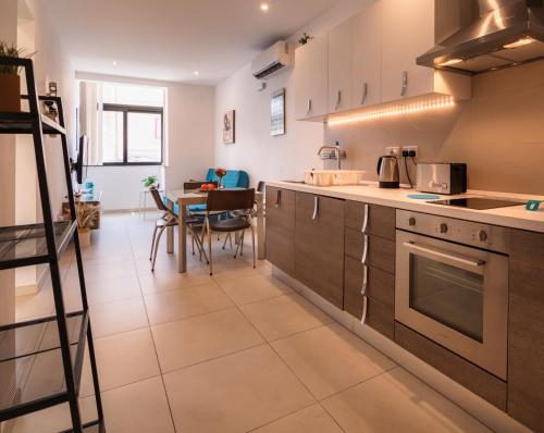 a kitchen with a staircase leading to a dining room at Modern Comfort - 2BR Apartment center of St Julians & Paceville in Paceville