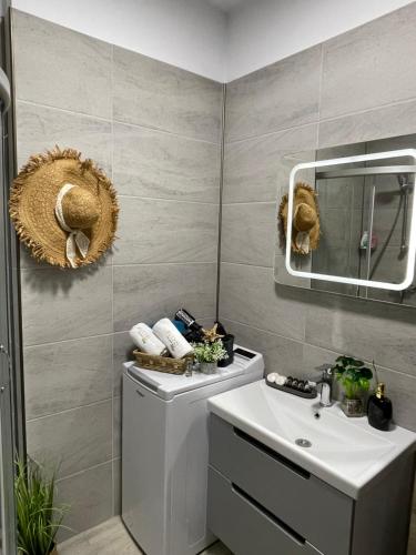 W łazience znajduje się biała umywalka i lustro. w obiekcie Mamaia Nord - Apartament Beach Resort w mieście Năvodari