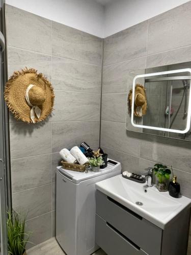 a bathroom with a white sink and a mirror at Mamaia Nord - Apartament Beach Resort in Mamaia Sat/Năvodari