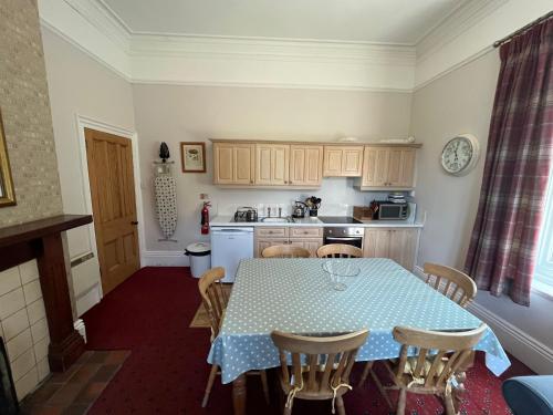 a kitchen with a table with a blue and white table cloth at Hargate Hall Self Catering in Buxton