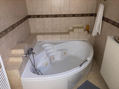 a white bath tub in a tiled bathroom at VILLA MARIA in Kanálion