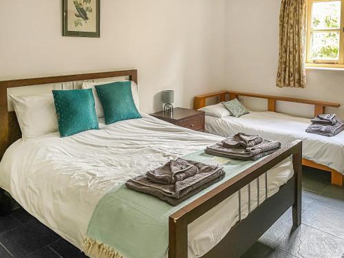 a bedroom with two beds with towels on them at Manor Farm Retreat in Hainford