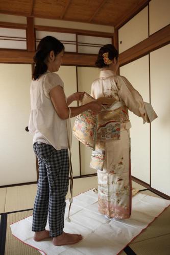 two women in kimonos standing on a rug at 帝塚山忍者屋敷 in Osaka