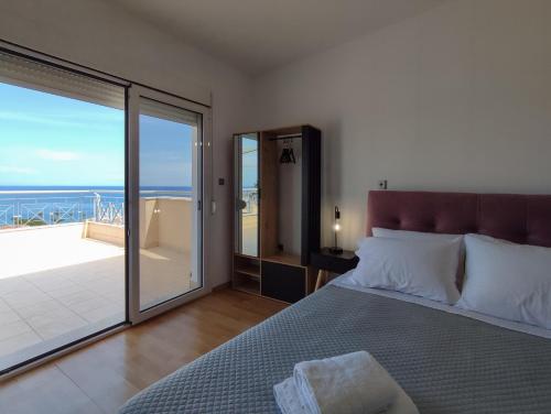 a bedroom with a bed and a view of the ocean at Stargaze Apartment with Sea View in Zakynthos Town