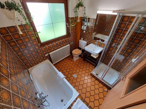a bathroom with a tub and a toilet and a sink at Koenigsapartments in Bad Kleinkirchheim