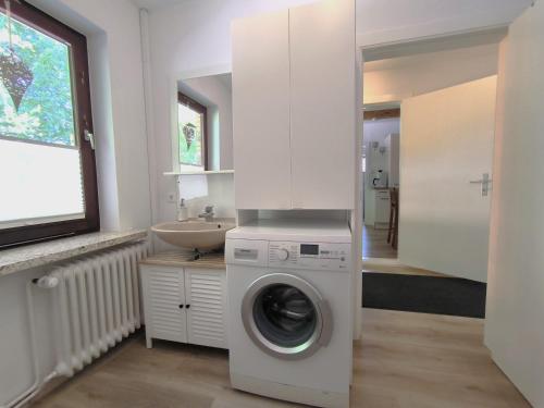 a washing machine in a bathroom with a sink at Ferienwohnung zwischen den Meeren - schöne und gemütliche FeWo mit Garten in Dörpstedt