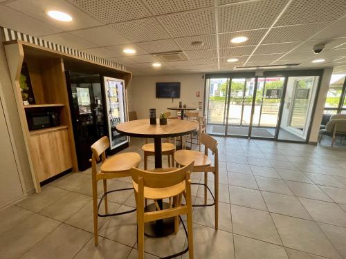 a restaurant with a table and chairs in a room at B&B HOTEL Lyon Aéroport Saint-Quentin-Fallavier in Saint-Quentin-Fallavier