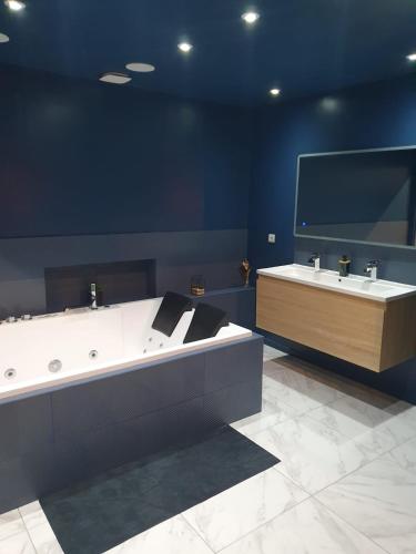 a bathroom with two sinks and a large bath tub at La Suite - Loft Spa in Tavernes