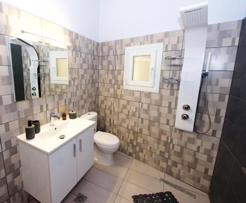 een badkamer met een toilet, een wastafel en een douche bij Fiorita Ionica in Achílleion