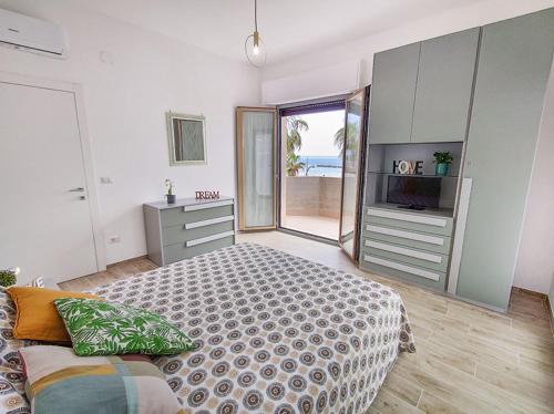 - une chambre avec un lit et une télévision dans l'établissement Appartamento Alighieri primissima fila mare, à Martinsicuro