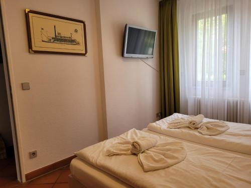 a hotel room with two beds and a tv on the wall at Ferienwohnung Abendstimmung in Dewichow