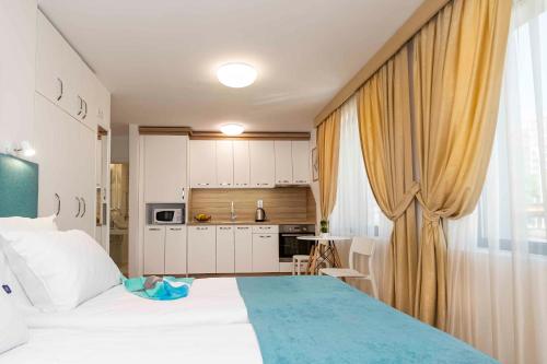 Un dormitorio con una cama grande y una cocina. en Електра Апарт Бургас Electra Apart Burgas Elektra Bourgas, en Burgas