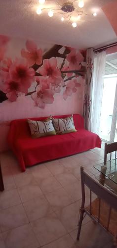 a bedroom with a red bed with flowers on the wall at Valloris Apartments in Hévíz