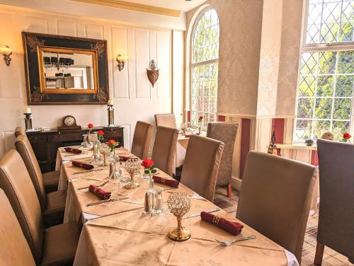 uma sala de jantar com uma mesa longa e cadeiras em Brookside Hotel & Restaurant ,Suitable for Solo Travelers, Couples, Families, Groups Education trips & Contractors welcome em Chester