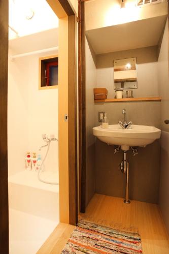 a bathroom with a sink and a bath tub at 帝塚山忍者屋敷 in Osaka