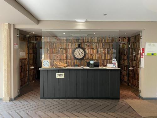 una biblioteca con un reloj en una pared de libros en Casa do Adro Hotel, en Ferreira do Zêzere