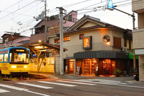 a train is pulling up to a building at 帝塚山忍者屋敷 in Osaka