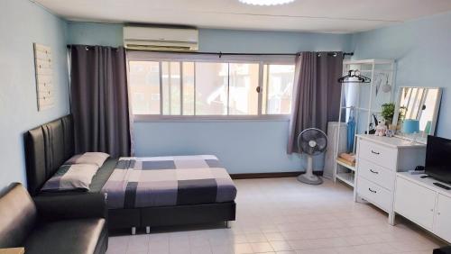 a bedroom with a bed and a tv and a window at Nesto Condo at Muangthong in Pak Kret