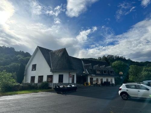 a large white building with a black roof and a car at Hello Astur Green in Bimenes